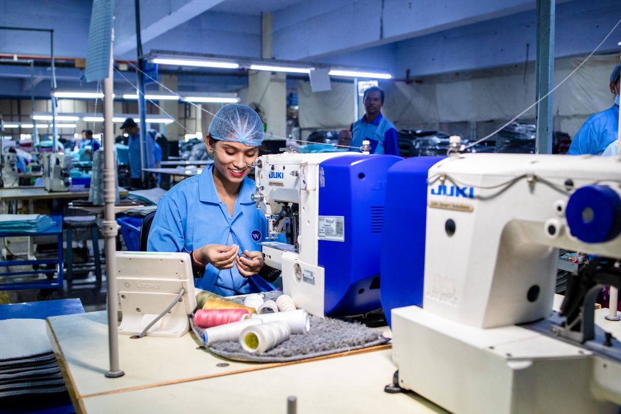 Workers in a textile factory operating sewing machines, showcasing blue collar work.